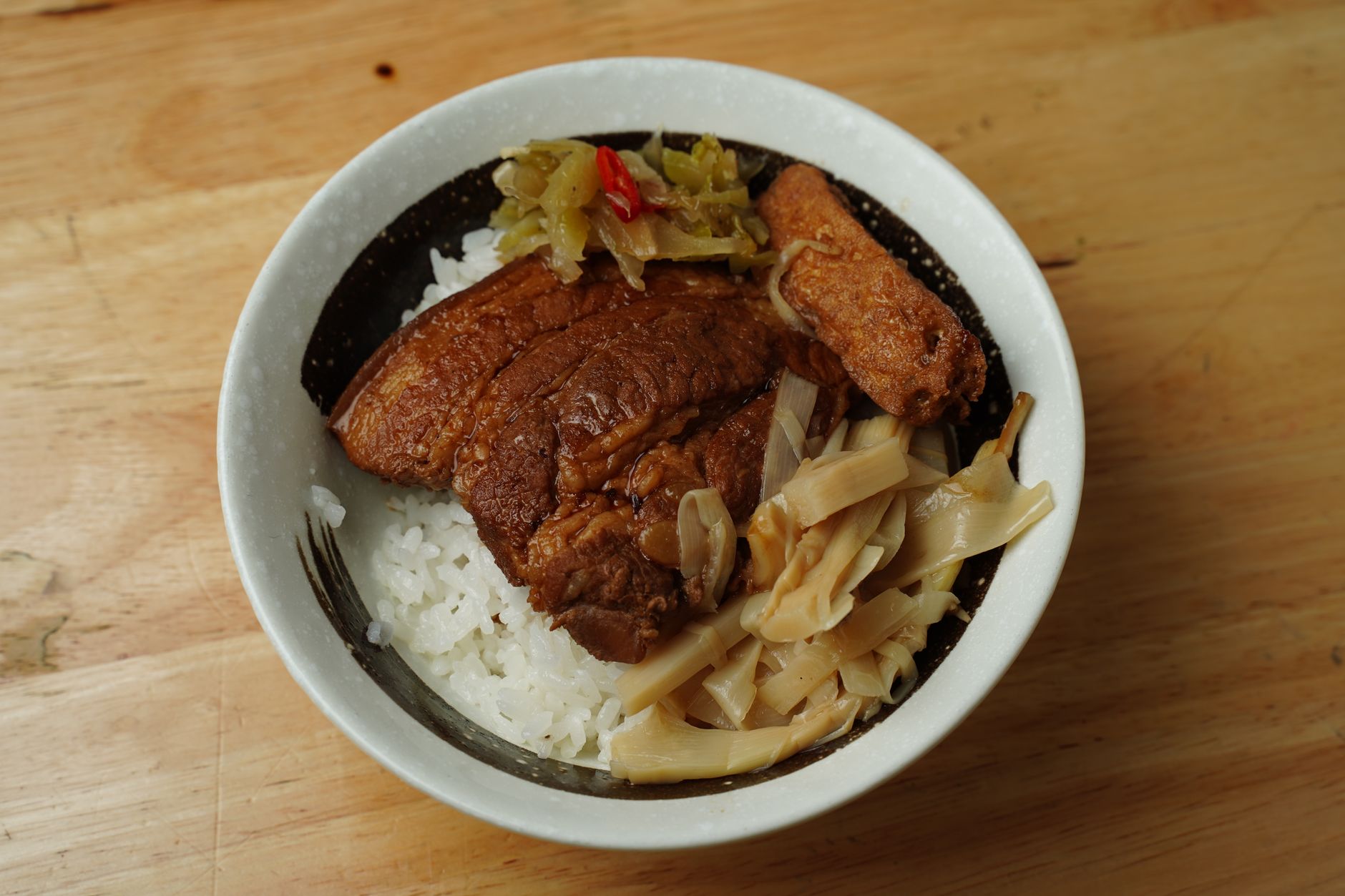 一碗完美滷肉飯的特寫:米飯粒粒分明,滷汁油亮,配半熟蛋黃緩緩流出